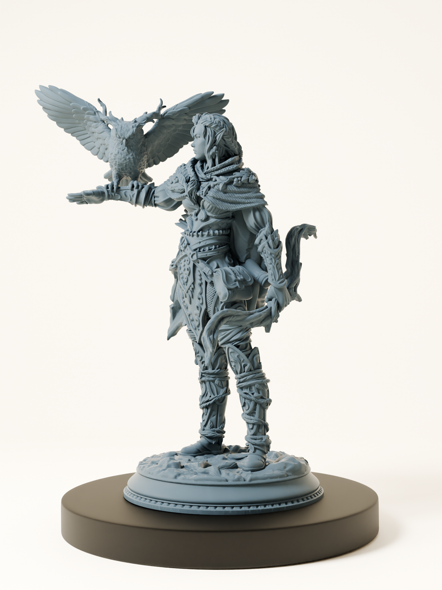 Figurine d’une elfe en armure légère, tenant un hibou aux bois féériques sur son bras tendu, posée sur un socle de pierre et de végétation.